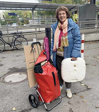 Christa Lippmann mit Fahnen und Infomaterial auf dem Weg zu Juki